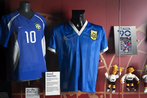 The soccer shirt, center, worn by Argentina's Diego Maradona in the 1986 World Cup quarterfinal against England is displayed at the National Football Museum in Manchester, England Nov. 26, 2020. The shirt worn by Diego Maradona when he scored the controversial “Hand of God” goal against England in the 1986 World Cup is for sale for the first time. Auctioneer Sotheby’s said Wednesday, April 6, 2022 that the jersey could fetch more than 4 million pounds ($5.2 million) in an online auction th