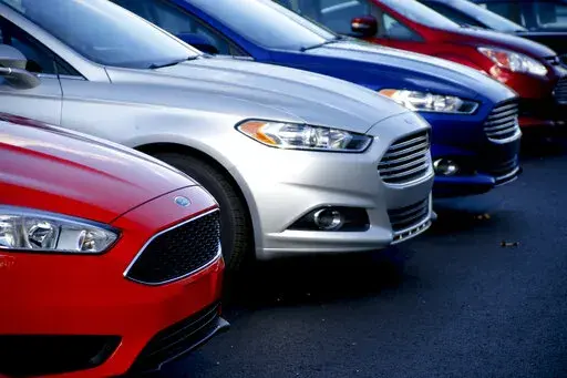A row of new Ford Fusions are for sale on the lot at Butler County Ford in Butler, Pa., Nov. 19, 2015. A shortage of computer chips and other parts hobbled the U.S. auto industry in 2022, slowing factories and contributing to an expected 8% decline in sales from the previous year. And although supplies are improving and prices are coming down a little, auto factories aren't likely to get back to full production until next year. (AP Photo/Keith Srakocic, File)