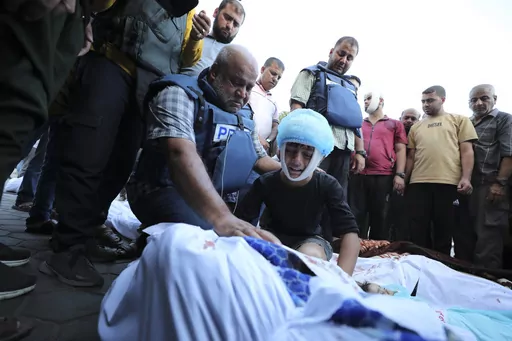 Al-Jazeera correspondent Wael Dahdouh, center, mourns his wife, son, daughter, and grandson, killed in an Israeli airstrike on Nuisserat refugee camp, outside a hospital in Deir al Balah, south of the Gaza Strip, Thursday, Oct. 26, 2023. (AP Photo/Ali Mahmoud)