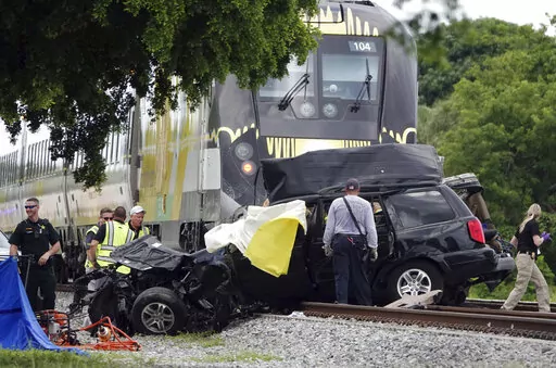 In this Aug 25, 2019 file photo, Broward Sheriff's Deputies and Pompano Beach Fire Rescue work the scene of a fatal accident on North Dixie Highway in Pompano Beach, Fla. South Florida's higher-speed railroad, other train lines and local officials  met with federal safety officials Wednesday, Feb. 23, 2022 to begin working out plans that they hope will decrease the number of fatal strikes between locomotives, cars and pedestrians. (Joe Cavaretta/South Florida Sun-Sentinel via AP)