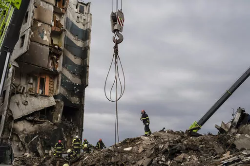 Firefighters work on a destroyed apartment building in the town of Borodyanka, Ukraine, on Saturday, April 9, 2022. Russian troops occupied the town of Borodyanka for weeks. Several apartment buildings were destroyed during fighting between the Russian troops and the Ukrainian forces in the town around 40 miles northwest of Kiev. (AP Photo/Petros Giannakouris)