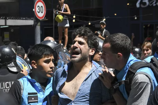 Police detain a protester for blocking the streets during an anti-government demonstration against the economic reforms of President Javier Milei in Buenos Aires, Argentina, Wednesday, Dec. 27, 2023. Milei's government has warned it will not allow protesters to block streets. (AP Photo/Gustavo Garello)