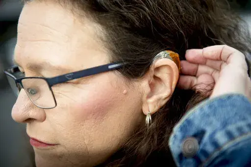 Kim M. Smith, leader of the Utah Deaf Hospital Rights movement and president of the Utah Association of the Deaf, brushes her hair away from her hearing aid as she poses for a portrait Monday, Jan. 20, 2020, at Alta View Hospital in Sandy, Utah.  Millions of Americans may be able to buy hearing aids without a prescription by this fall, under a long-awaited rule finalized Tuesday, Aug. 16, 2022, that's intended to make the devices more accessible to people with hearing problems. The Food and Drug