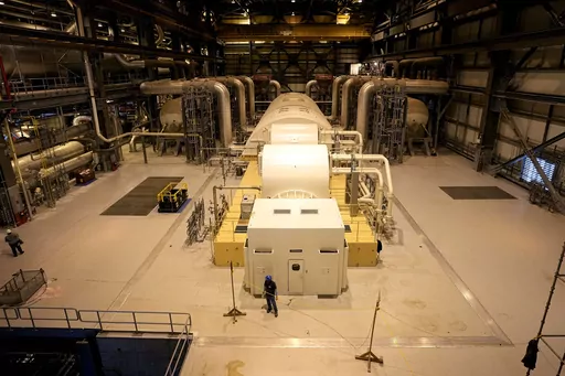 A turbine that generates electricity using steam heated by nuclear fission sits at Georgia Power Co.'s Plant Vogtle nuclear power plant Jan. 20, 2023, in Waynesboro, Ga. Company officials announced Friday, June 16, 2023, that the turbine's hydrogen cooling system had a problem with its seal, pushing back the commercial operation date of Unit 3, one of two new reactors at the site, to July. (AP Photo/John Bazemore, File)