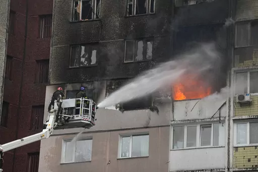 Firefighters work to extinguish a fire in an apartment building after Russian attack in Kyiv, Ukraine, Wednesday, Feb. 7, 2024. Authorities say Russia has fired cruise and ballistic missiles and Shahed-type drones at targets across Ukraine including the capital Kyiv. Officials said the Wednesday morning attack killed at least one civilian and injured 10 others. (AP Photo/Efrem Lukatsky)