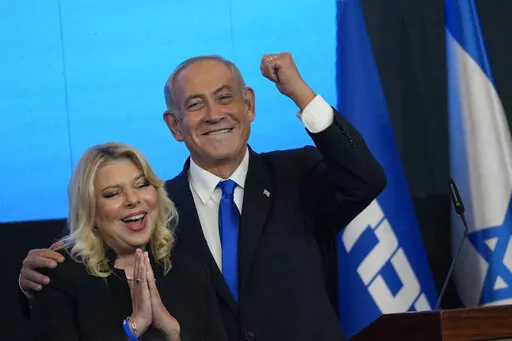 Former Israeli Prime Minister and the head of Likud party, Benjamin Netanyahu and his wife Sara gesture after first exit poll results for the Israeli Parliamentary election at his party's headquarters in Jerusalem, Wednesday, Nov. 2, 2022. Netanyahu and his allies on Thursday denounced protesters as "anarchists" after they massed outside a Tel Aviv salon where his wife was getting her hair done, a chaotic end to a day of demonstrations against the government's plan to overhaul the judiciary. (AP