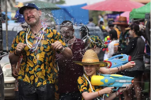 A man sprays water at western tourists to celebrate Songkran festival in Prachinburi Province, east of Bangkok. Thursday, April 13, 2023, Hordes of revelers toted colorful water guns Thursday as Thailand kicked off its exuberant three-day Songkran festival at full blast for the first time since 2019, hoping for a significant boost in tourism after the industry was devastated by coronavirus travel restrictions.(AP Photo/Wason Wanichakorn)