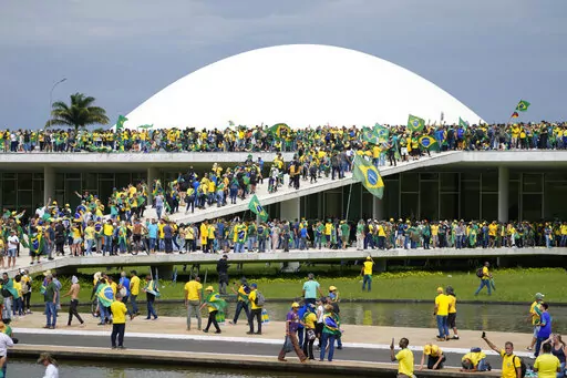 Protesters, supporters of Brazil's former President Jair Bolsonaro, storm the the National Congress building in Brasilia, Brazil, Jan. 8, 2023. Brazil’s federal police searched the home of a nephew of Bolsonaro on Friday, Jan. 27, 2023, in connection with the Jan. 8 storming of government buildings in the capital by far-right protesters. (AP Photo/Eraldo Peres, File)