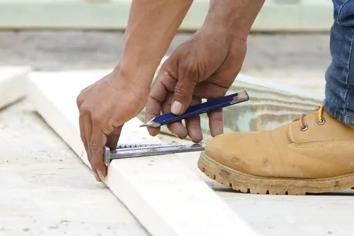 A workman measures uses a rafter to mark a beam for trimming at a new housing site in Madison County, Miss., Tuesday, March 16, 2021.   If you’re getting ready to buy a home, you’ve probably been saving for the down payment and other closing costs.   A home improvement fund can help ensure your newly purchased house is a well-functioning, comfortable home. Here’s why home improvement savings are a homebuyer must-have and how to build yours.(AP Photo/Rogelio V. Solis)