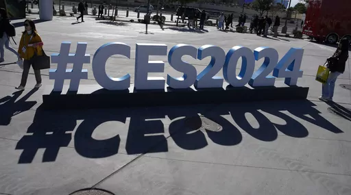 People walk by a CES sign during the CES tech show, Jan. 10, 2024, in Las Vegas. The best CES products pierce through the haze of marketing hype at the Las Vegas gadget show to reveal innovations that could improve lives. The worst could harm us or our society and planet in such “innovatively bad” ways that a panel of self-described dystopia experts has judged them “Worst in Show.” The third annual contest that no tech company wants to win announced its decisions Thursday, Jan. 11, and f