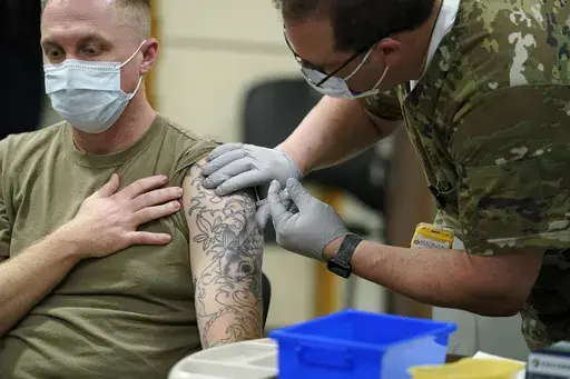 Staff Sgt. Travis Snyder receives the first dose of the Pfizer COVID-19 vaccine given at Madigan Army Medical Center at Joint Base Lewis-McChord in Washington state, Dec. 16, 2020, south of Seattle. (AP Photo/Ted S. Warren, File)