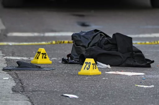 A witch hat, left, and an unidentified object are shown in the street near evidence markers in the Ybor City section of Tampa, Fla., after a shooting, Oct. 29, 2023. Shootings across the U.S. over the party weekend before Halloween have left at least 11 people dead and more than 70 injured. Authorities say the deaths between Friday and Sunday included two in Tampa, Florida, three in Texarkana, Texas, and two each in Kansas, San Antonio, Texas and Mansfield, Ohio. Many involved altercations arisi