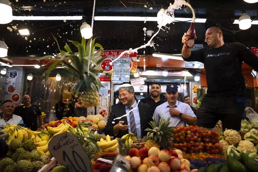 Israeli far-right lawmaker and the head of "Jewish Power" party, Itamar Ben-Gvir, center, and his supporters visit at Hatikva Market in Tel Aviv during his campaign ahead of the country's election, Friday, Oct. 21, 2022. (AP Photo/Oded Balilty, File)