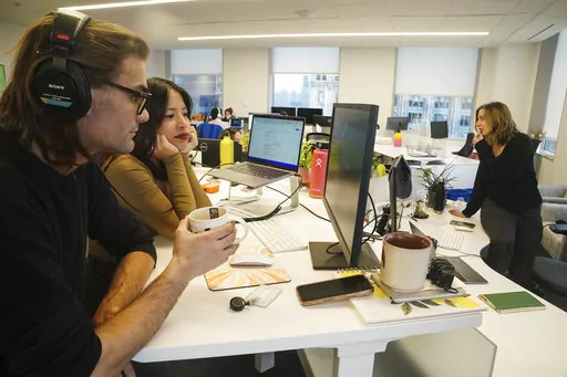 John D'Amico, deputy executive editor for The News Movement (TNM), a social media news operation re-imagined for Gen-Z consumers, left, reviews video with reporter Kimberly Avalos, Wednesday, March 1, 2023, in New York. TNM uses a staff of reporters with an average age of 25 to make tailored news content for sites like TikTok, Instagram, YouTube and Twitter. (AP Photo/Bebeto Matthews)