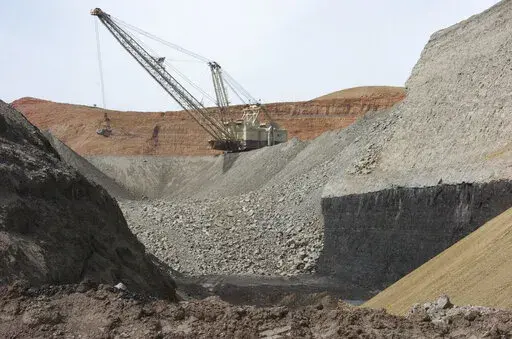 In this April 4, 2013, file photo, a dragline excavator moves rocks above a coal seam at the Spring Creek Mine in Decker, Mont. A federal judge has reinstated a moratorium on coal leasing from federal lands that was imposed under former President Barack Obama and then scuttled under former President Donald Trump, Friday, Aug. 12, 2022. (AP Photo/Matthew Brown, File)