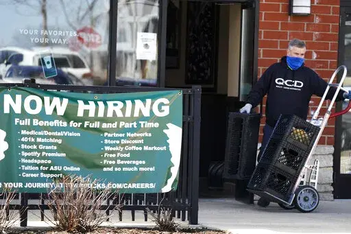 A hiring sign is displayed outside of a Starbucks in Schaumburg, Ill., Friday, April 1, 2022.  The number of Americans applying for jobless aid ticked up slightly last week but the total number of Americans collecting benefits remained at its lowest level in more than five decades. Applications for unemployment benefits rose by 1,000 to 203,000 for the week ending May 7, the Labor Department reported Thursday, May 12.  (AP Photo/Nam Y. Huh)