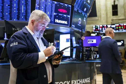 In this photo provided by the New York Stock Exchange, a pair of traders work on the floor, Thursday, April 7, 2022. Stocks shifted between small gains and losses in morning trading on Wall Street Thursday as investors continue weighing the latest updates from the Federal Reserve amid concerns about rising inflation. (David L. Nemec/New York Stock Exchange via AP)