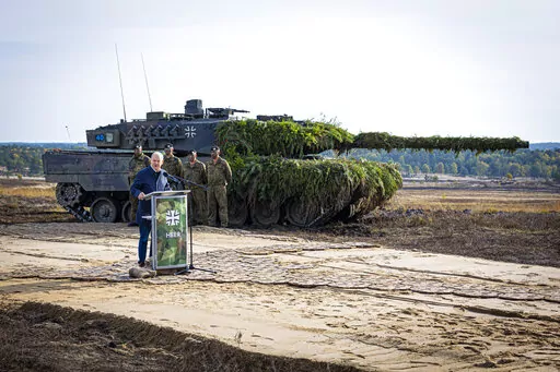 German Chancellor Olaf Scholz speaks to soldiers in front of a Leopard 2 main battle tank after the Army's training and instruction exercise in Ostenholz, Germany, Monday, oct. 17, 2022. Germany has become one of Ukraine's leading weapons suppliers in the 11 months since Russia's invasion. The debate among allies about the merits of sending battle tanks to Ukraine has focused the spotlight relentlessly on Germany, whose Leopard 2 tank is used by many other countries and has long been sought by K