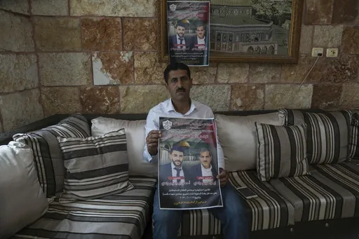 Abdelazim Wadi, 50, holds up a poster commemorating his brother, Ibrahim Wadi, and his nephew, Ahmed Wadi, who were killed by Israeli settlers during a funeral procession on Oct. 12 in the rural Palestinian village of Qusra, West Bank, Sunday, Nov. 12, 2023. With the world’s attention focused on the fighting in Gaza, Israeli settler violence against Palestinians since Oct. 7 has surged to the highest levels ever recorded by the United Nations. Palestinians say this Israel-Hamas war has left th