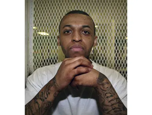 Texas death row inmate Steven Lawayne Nelson poses for a photo in a visiting cage at the Texas Department of Criminal Justice Polunsky Unit outside Livingston, Texas, on Dec. 5, 2012. (AP Photo/Michael Graczyk, File)