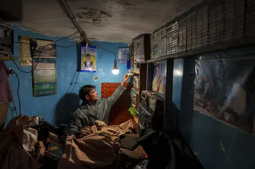 Farooq Ahmad Shaksaaz searches for a favorite cassette tape at his tailor shop in the outskirts of Srinagar, Indian controlled Kashmir, Friday, Feb. 14, 2025. (AP Photo/Dar Yasin)