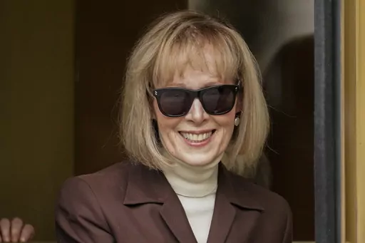 E. Jean Carroll, center, walks out of Manhattan federal court, Tuesday, May 9, 2023, in New York. In a written submission Thursday, June 8, 2023, lawyers for Donald Trump say a $5 million jury award for his sexual abuse and defamation of columnist E. Jean Carroll in a department store dressing room, in 1996, should be slashed to less than $1 million. (AP Photo/John Minchillo)
