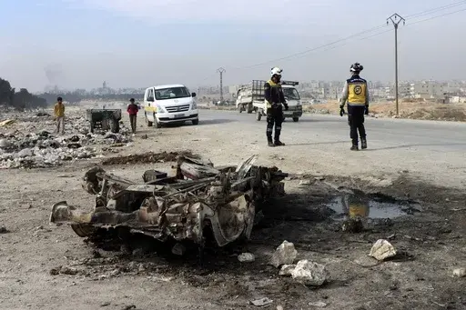 In this photo provided by the Syrian Civil Defense White Helmets, which has been authenticated based on its contents and other AP reporting, Syrian White Helmet civil defense workers inspect the area of a car bomb attack that killed least 15 people and wounded dozens, the local Syrian civil defense reported, on the outskirts of the city of Manbij, Syria, Monday. Feb. 3, 2025. (Syrian Civil Defense White Helmets via AP)