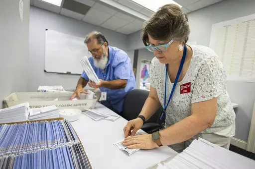 Dawn Stephens, right, and Duane Taylor prepare ballots to be mailed at the Mecklenburg County Board of Elections in Charlotte, N.C., Thursday, Sept. 5, 2024. (AP Photo/Nell Redmond)