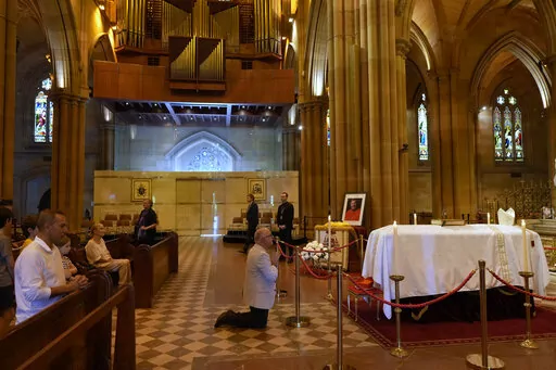 The coffin of Cardinal George Pell lays in state at St. Mary's Cathedral in Sydney, Wednesday, Feb. 1, 2023. Mourners paid their respects to Cardinal George Pell who lay in state in a Sydney cathedral on Wednesday as police sought a court order to prevent protesters from disrupting his funeral. (AP Photo/Rick Rycroft, Pool)
