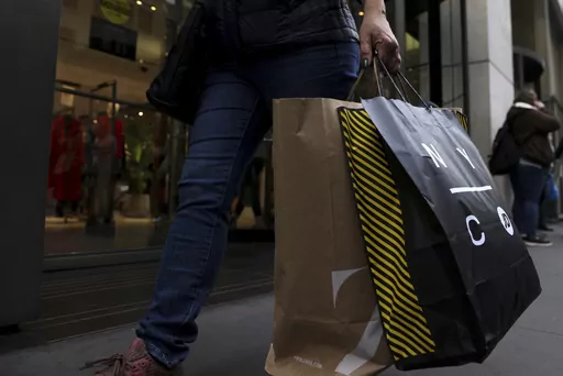 A shopper carries bags down Fifth Avenue on Nov. 25, 2022, in New York. Making returns will be more difficult this holiday season because more retailers are charging return fees, but there are ways to avoid them. Reviewing stores’ return policies before buying can mean fewer unpleasant surprises later. In some cases, joining a loyalty program can allow shoppers to avoid return fees while also offering access to early sales and exclusive offers. (AP Photo/Julia Nikhinson, File)