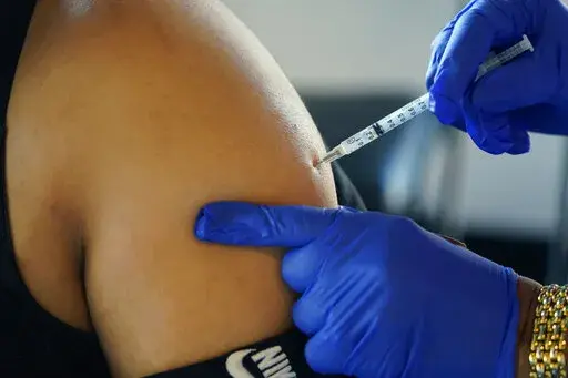 A Jackson, Miss., resident receives a Pfizer booster shot from a nurse at a vaccination site Tuesday, Feb. 8, 2022. In August 2022, Pfizer and Moderna both asked U.S. regulators to authorize modified versions of their booster vaccine — shots that are half the original recipe and half protection against BA.4 and BA.5, the newest subtypes of the coronavirus omicron variant. (AP Photo/Rogelio V. Solis, File)