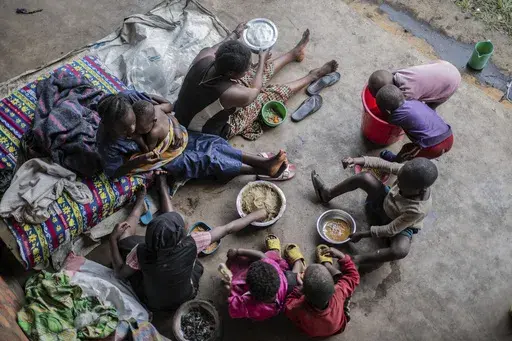 Zawadi Sifa who has been fleeing fighting from camp to camp, shares food with her seven children in Goma, Democratic Republic of the Congo, Thursday, Feb. 5, 2025.(AP Photo/Moses Sawasawa)