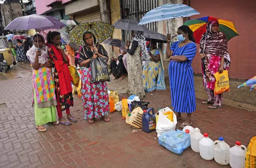 Women wait in a queue to buy kerosene in in Colombo, Sri Lanka, Saturday, June 11, 2022. Sri Lanka's economic crisis, the worst in its history, has completely recast the lives of the country's once galloping middle class. For many families that never had to think twice about fuel or food, the effects have been instant and painful, derailing years of progress toward lifestyles aspired to across South Asia. (AP Photo/Eranga Jayawardena)