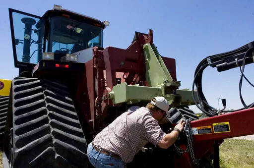 Farmer Nathan Weathers configures a high-power, high-tech quad-track tractor near his farm in Yuma, Colo, June 30, 2008. Lawmakers in Colorado and 10 other states have introduced bills that would force farming equipment manufacturers to provide the tools, software, parts and manuals needed for farmers to do their own repairs. The bills are a response to farmers unable to repair their own tractors and combines, forcing them to wait sometimes days and paying steep labor costs. (Brian Brainerd/The 