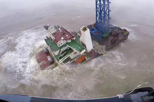 In this image released by Hong Kong Government Flying Service, a helicopter with rescue crew members approaches a sinking ship in the South China Sea, 300 kilometers (186 miles) south of Hong Kong on July 2, 2022, as Typhoon Chaba was moving in the area. A fourth crew member has been rescued Monday, July 4, 2022 after the typhoon sunk the engineering vessel earlier this week, according to a Chinese state broadcaster. (Hong Kong Government Flying Service via AP)