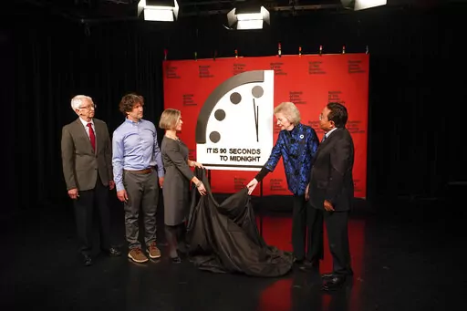 Siegfried Hecker, from left, Daniel Holz, Sharon Squassoni, Mary Robinson and Elbegdorj Tsakhia with the Bulletin of the Atomic Scientists, remove a cloth covering the Doomsday Clock before a virtual news conference at the National Press Club in Washington, Tuesday, Jan. 24, 2023. The Bulletin of the Atomic Scientists announced that it has moved the minute hand of the Doomsday Clock to 90 seconds to midnight. (AP Photo/Patrick Semansky)