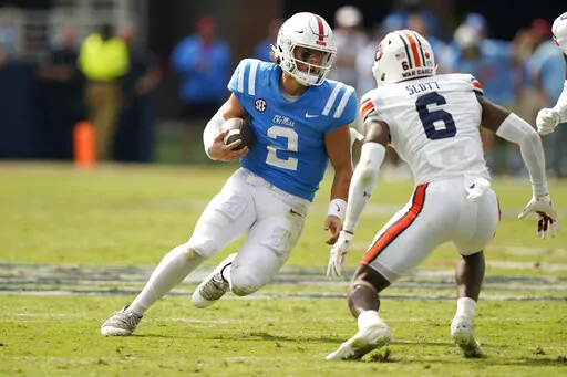 Mississippi quarterback Jaxson Dart (2) tries to evade a tackle attempt by Auburn cornerback Keionte Scott (6) during the second half of an NCAA college football game in Oxford, Miss., Saturday, Oct. 15, 2022. Mississippi won 48-34. (AP Photo/Rogelio V. Solis)