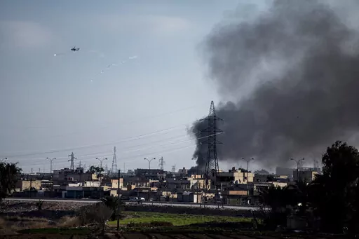 US attack helicopter shoots flares in Hassakeh, northeast Syria, Wednesday, Jan. 26, 2022. With a spectacular jail break in Syria and a deadly attack on an army barracks in Iraq, the Islamic State group was back in the headlines the past week, a reminder of a war that formally ended three years ago but continues to be waged away from view. (AP Photo/Baderkhan Ahmad, File)
