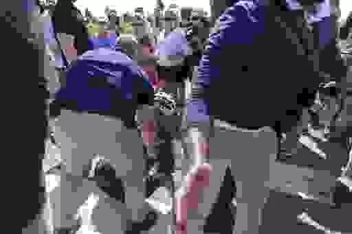 President Joe Biden is helped by U.S. Secret Service agents after he fell trying to get off his bike to greet a crowd on a trail at Gordons Pond in Rehoboth Beach, Del., Saturday, June 18, 2022.  On Friday, June 24, The Associated Press reported on stories circulating online incorrectly claiming the Atlantic published an article with the headline, “The Heroism of Biden’s Bike Fall” after Biden fell on Saturday as he tried to dismount his bicycle. (AP Photo/Manuel Balce Ceneta, File)