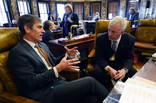 FILE -Briggs Hopson, R-Vicksburg, left, and David Blount, D-Jackson confer following adjournment at the Mississippi State Capitol in Jackson, Miss., Tuesday, Jan. 4, 2022. Mississippi legislators are working on proposals to fund state government for the year that begins July 1. The Republican-controlled House and Senate on Thursday, Feb. 17, 2022 passed the first draft of budget bills for schools, health care, transportation and other state services. (AP Photo/Rogelio V. Solis, File)