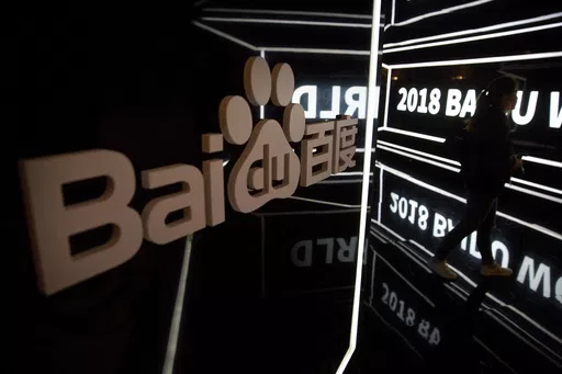 An attendee walks past a display at the Baidu World conference in Beijing, on Nov. 1, 2018. A top public relations executive from Chinese technology firm Baidu apologized Thursday, May 9, 2024, after she made comments in a series of videos that critics said glorified a culture of overwork. (AP Photo/Mark Schiefelbein, File)