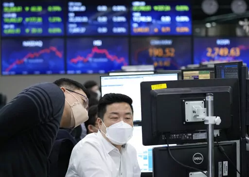 Currency traders watch monitors at the foreign exchange dealing room of the KEB Hana Bank headquarters in Seoul, South Korea, Thursday, March 31, 2022. Asian stock markets sank Thursday after Chinese manufacturing weakened and Russian shelling around Ukraine's capital shook hopes of progress in peace talks. (AP Photo/Ahn Young-joon)
