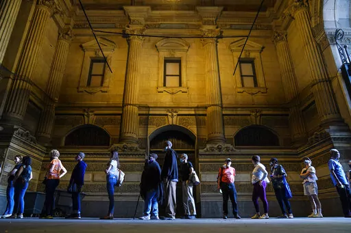 Voters wait in line to make corrections to their ballots for the midterm elections at City Hall in Philadelphia, Monday, Nov. 7, 2022. According to data from AP VoteCast, voters with no religious affiliation supported Democratic candidates and abortion rights by staggering percentages in the 2022 midterm elections. (AP Photo/Matt Rourke)