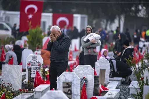 People visit graves in a cemetery where some of the victims of the earthquake in Feb. 2023 are buried in Antakya, southern Turkey, Tuesday, Feb. 6, 2024. (AP Photo/Metin Yoksu, File)
