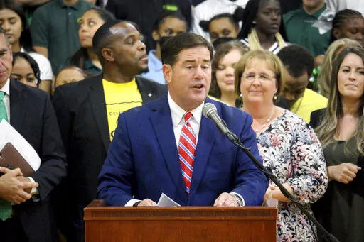 Republican Arizona Gov. Doug Ducey speaks at an event touting a new universal school voucher program he signed into law in July and resigned again in a ceremony Tuesday, Aug. 16, 2022 at Phoenix Christian Preparatory School. The law will be the nation's most expansive voucher program, allowing all students to take public money to attend private schools, if opponents fail to block it by collecting enough signatures to refer it to the ballot. (AP Photo/Bob Christie)