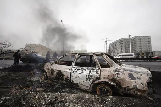 A car, which was burned after clashes, is seen on a street in Almaty, Kazakhstan, Friday, Jan. 7, 2022. Kazakhstan's president authorized security forces on Friday to shoot to kill those participating in unrest, opening the door for a dramatic escalation in a crackdown on anti-government protests that have turned violent. The Central Asian nation this week experienced its worst street protests since gaining independence from the Soviet Union three decades ago, and dozens have been killed in the 