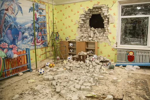 Bricks and debris mixes with toys below a damaged wall after the reported shelling on a kindergarten in the settlement of Stanytsia Luhanska, Ukraine Thursday late, Feb. 17, 2022. UU.S. President Joe Biden sounded unusually dire Thursday, as he warned that Washington saw no signs of a promised Russian withdrawal — but instead saw more troops moving toward the border with Ukraine, indicating Moscow could invade within days. (AP Photo/Oleksandr Ratushniak)