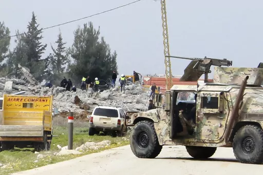 A Lebanese army vehicle block a road leading to a destroyed warehouse, background, which was attacked by Israeli airstrikes, on the outskirts of the Hezbollah stronghold village of Buday, near Baalbek town, east Lebanon, Monday, Feb. 26, 2024. The Israeli military says its air force struck targets of the militant Hezbollah group "deep inside Lebanon," where residents reported explosions near the northeastern city of Baalbek. (AP Photo)