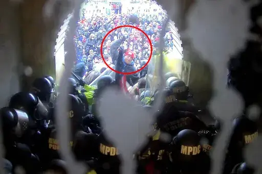 In this image from U.S. Capitol Police security video, released and annotated by the Justice Department in the Statement of Facts supporting an arrest warrant, Shane Jenkins, circled in red, is seen holding an object near the Lower West Terrace tunnel at the U.S. Capitol on Jan. 6, 2021, in Washington. Jenkins was sentenced to seven years in prison. (Justice Department via AP)