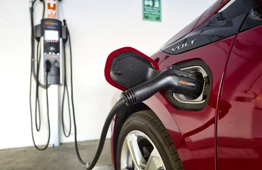 A Chevrolet Volt hybrid car is seen charging at a ChargePoint charging station at a parking garage in Los Angeles, Oct. 17, 2018. Sixteen states across the country that have tied their vehicle emission standards to California's now face weighty decisions on whether to follow that state's strictest-in-the nation new rules and require that all new cars, pickups and SUVs be electric or hydrogen powered by 2035. (AP Photo/Richard Vogel, File)
